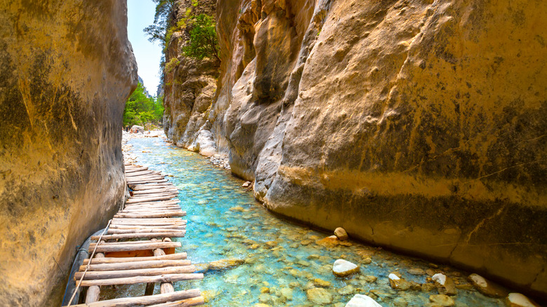 Un chemin de pont en bois le long du ruisseau de gorges de Samarie en Crète.