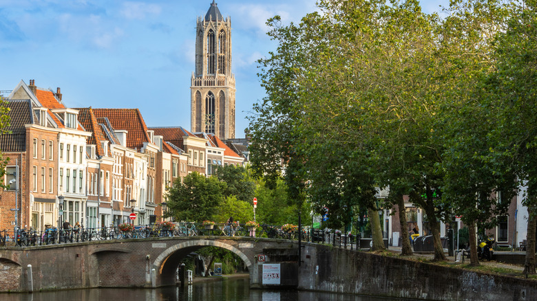 Tour Dom avec des bâtiments historiques le long d'un canal à Utrecht, Pays-Bas