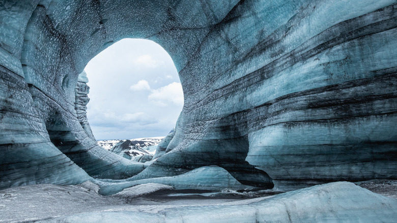 Murs en couches blancs, gris et noirs de glace et de cendres volcaniques dans la grotte de glace Katla en Islande
