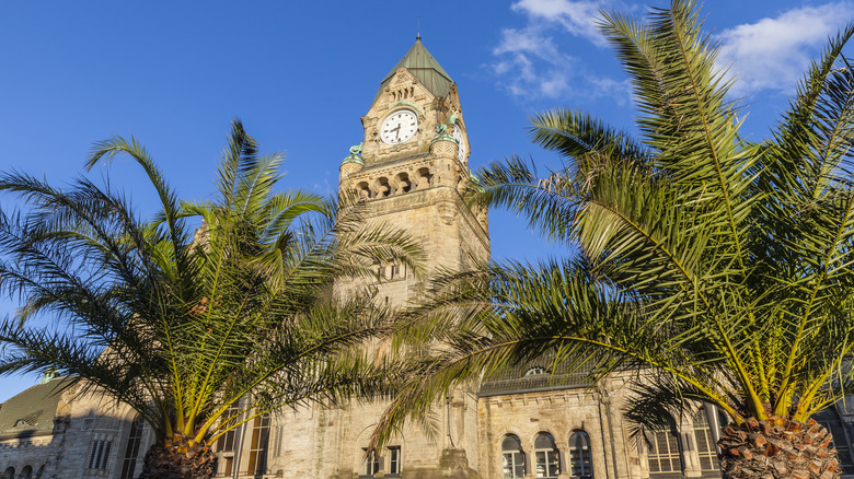 Clocktower et gare avec des palmiers à Metz, en France, par une journée ensoleillée