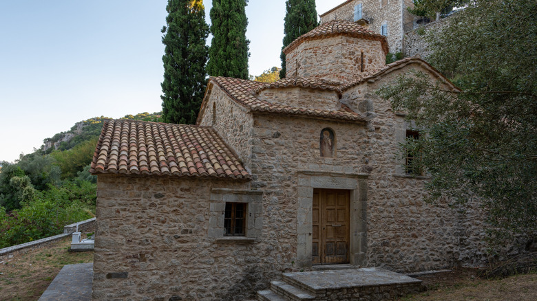 Petite église en pierre avec une porte en bois et plusieurs fenêtres à Karytaina