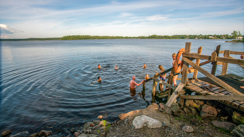 Des gens nageant dans un lac en Finlande.