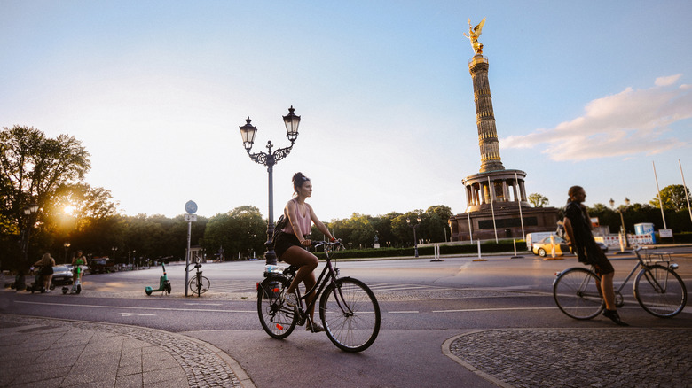 Femme à vélo avec la colonne de victoire de Berlin en arrière-plan.