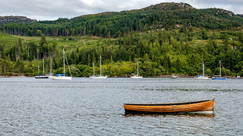 Un canoë et des voiliers attachés au loch