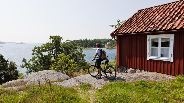Un cycliste à côté d'une cabane rouge sur une île