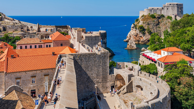 Touristes marchant le long des murs de Dubrovnik