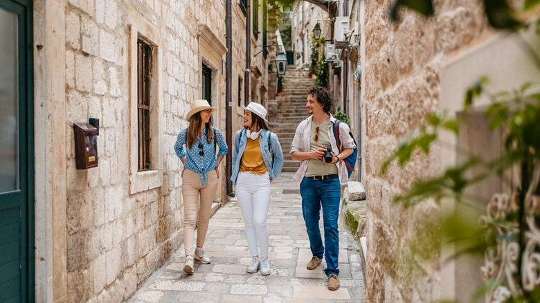 Trois touristes marchant dans les rues étroites de Dubrovnik