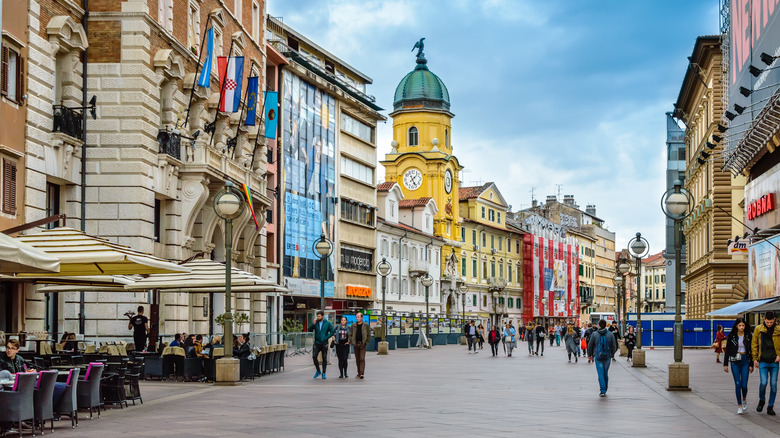 Vue sur la tour de l'horloge de la ville et Korzo, la principale promenade remplie de magasins, de cafés et de touristes à pied, dans la ville de Rijeka dans la baie de Kvarner, Croatie, un jour ensoleillé