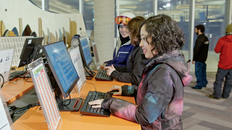 Les gens dans une boutique de location utilisant des ordinateurs publics