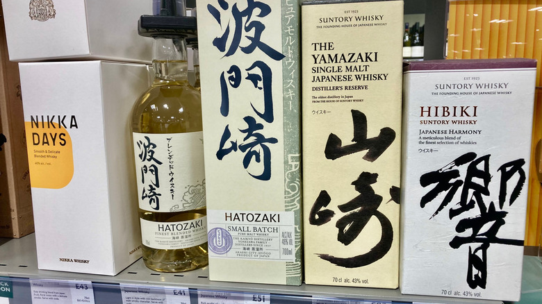 Une rangée de whiskies japonais est alignée dans un magasin d'alcools