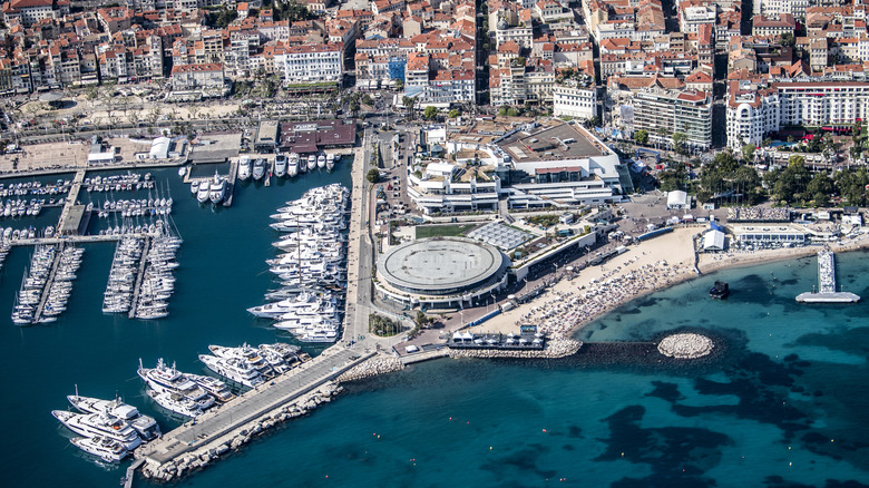 Une vue aérienne de Cannes, en particulier la marina, avec de l'eau bleue claire remplie de toutes sortes de bateaux