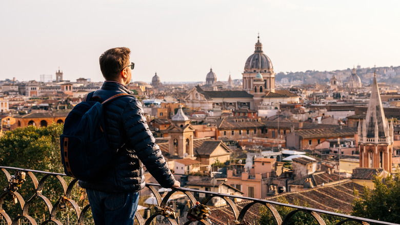 Voyageur portant une veste regardant les toits de Rome