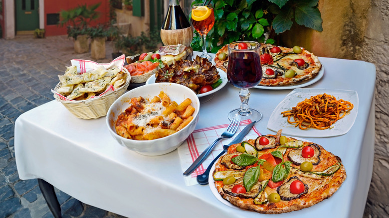 Une table remplie de pâtes traditionnelles, de pizzas et de vin dans le nord de l'Italie