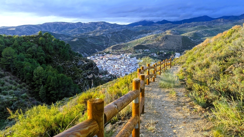 Un chemin le long des montagnes de la Sierra Nevada espagnol surplombant une ville blanchie à la chaux