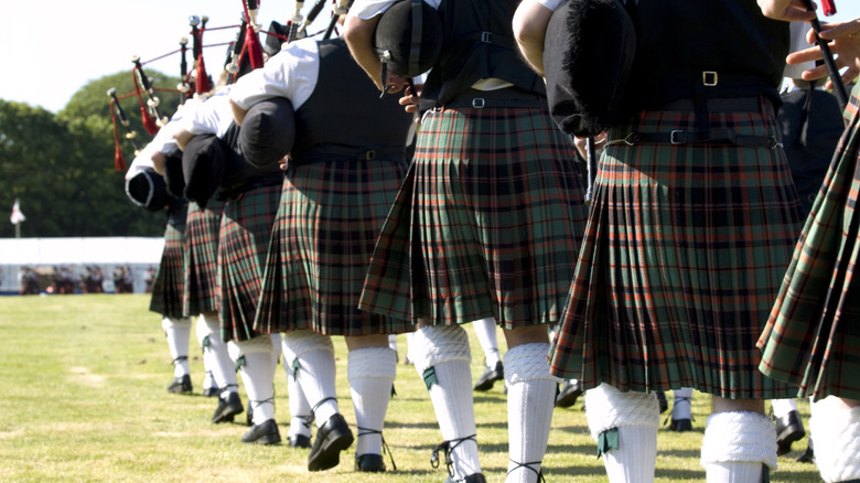 Les cornemuseurs participent au tatouage militaire écossais traditionnel en marchant dans une seule ligne de fichiers, tous vêtus de kilts