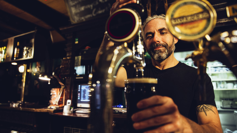Un barman versant Guinness d'un projet.