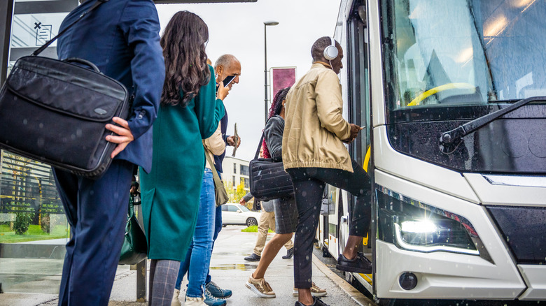 Les passagers font la queue pour monter à bord d'une ville