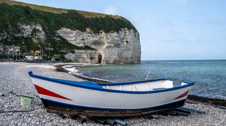 Boat de pêcheur traditionnel rouge, blanc et bleu sur la plage de Yport, France