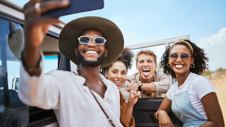 Jeune groupe d'amis prenant un selfie pendant les vacances de safari nature en Afrique.