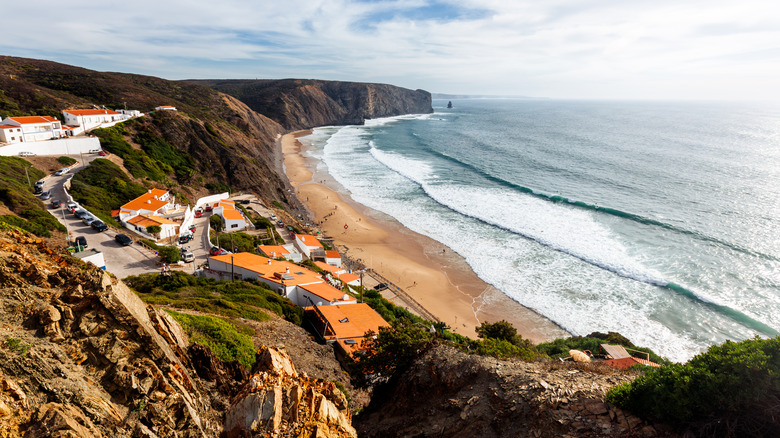 Les vagues roulent dans la plage d'Arrifana juste à l'extérieur d'Aljezur
