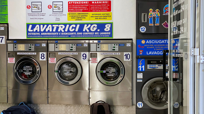 Une rangée de machines avec des instructions dans une laverie italienne