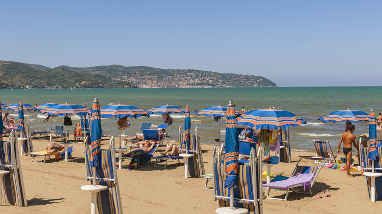 Parasols de plage et baigneurs sur la plage de sable