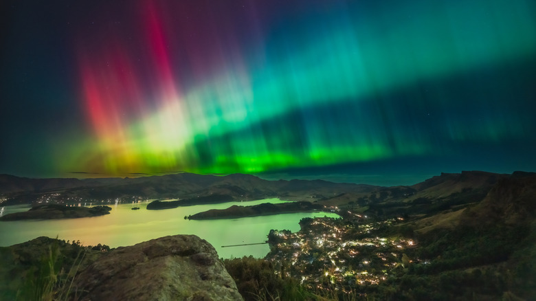Ribbons colorés de l'Aurora Australis sur une ville côtière de Nouvelle-Zélande la nuit