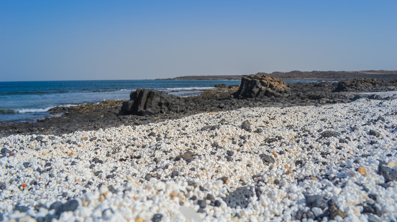Un coup de niveau du sol révèle que le sable sur la plage de pop-corn ressemble à des grains de pop-corn blanc et jaune