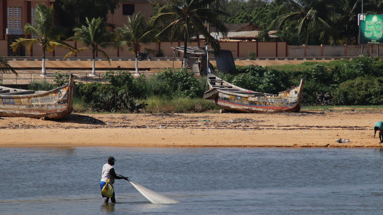 Un pêcheur jette un filet à offshore ANÉHO PLACE, TOGO
