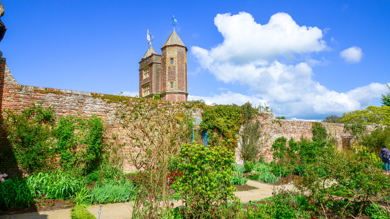 Lit de fleurs et un mur couvert de vigne devant la tour du château de Sissinghurst, en Angleterre