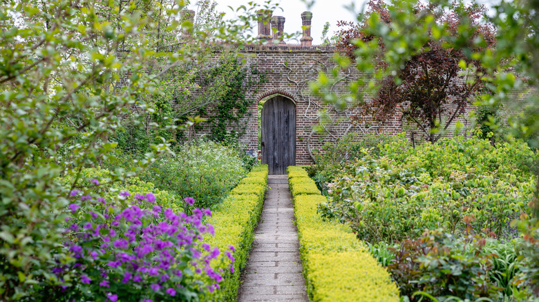 Un chemin de jardin menant à un mur de briques au château de Sissinghurst, en Angleterre,