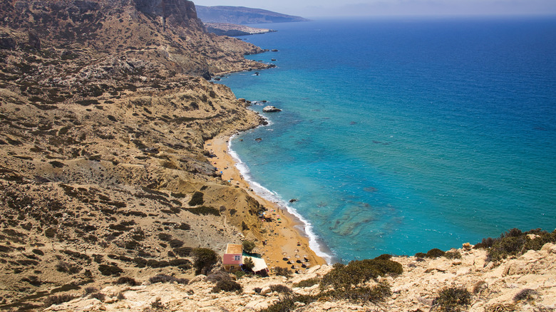 Une vue vers la plage rouge, assise autour du promontoire depuis Matala