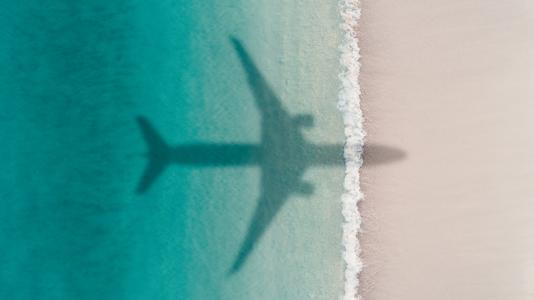 L'ombre d'un avion survain une plage