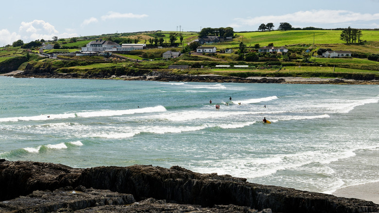 Par une belle journée à Inchydoney Beach, les surfeurs roulent de doux vagues