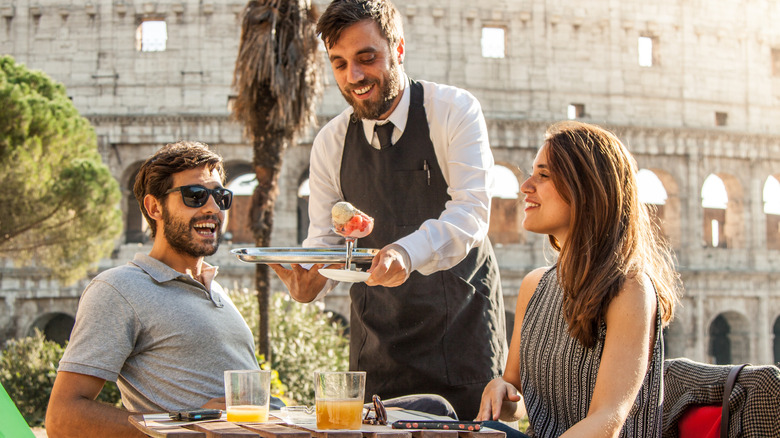 Serveur italien servant de la glace à un couple en Italie