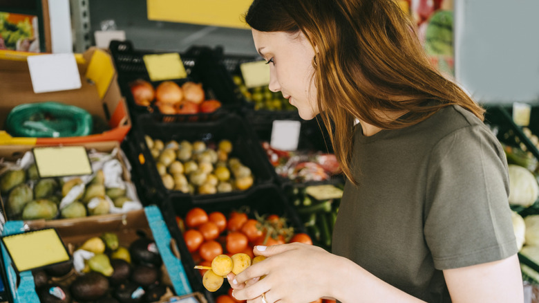 Femme achetant des produits avec des fruits dans ses mains