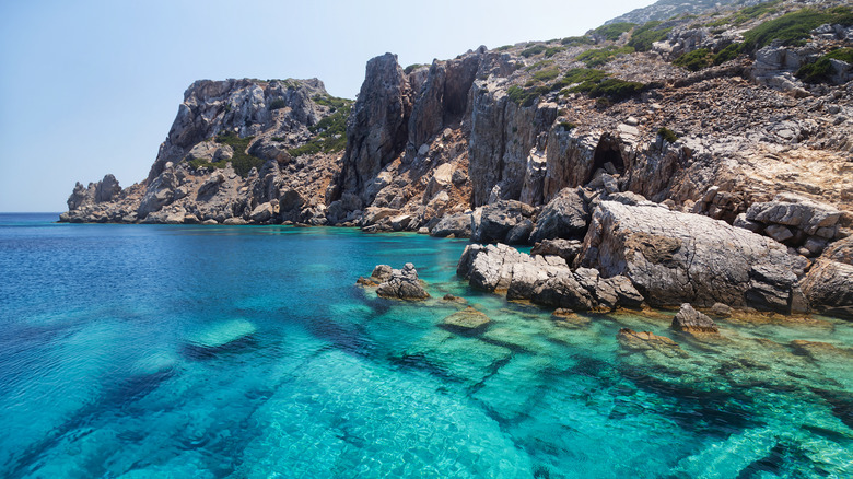 Eau turquoise cristalline près d'un littoral accidenté avec des falaises abruptes sur l'île Saria