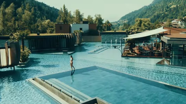 Femme marchant le long d'une piscine à débordement à Quellenhof Voir Lodge à Merano, en Italie