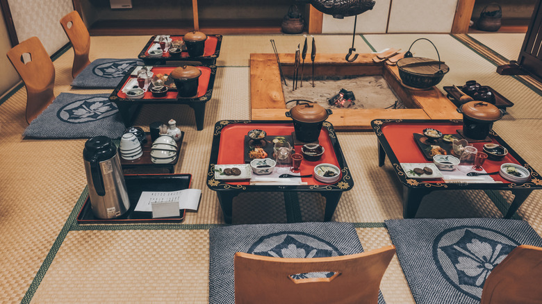 Un dîner gastronomique japonais Kaiseki avec une cheminée IRORI traditionnelle à Ryokan.