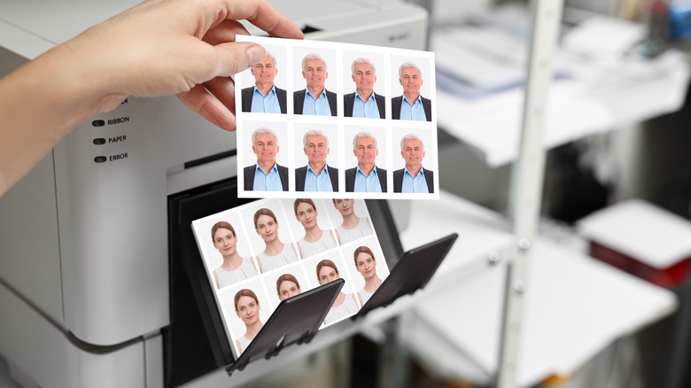 La main d'une femme tirant des photos de passeport d'une imprimante
