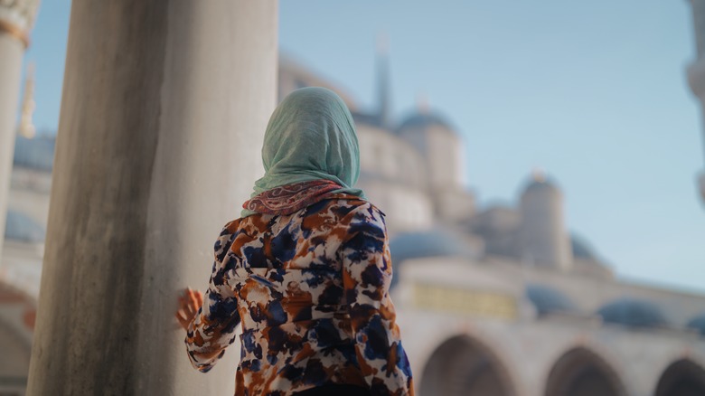 Femme aux cheveux couvrant dans le terrain de la mosquée