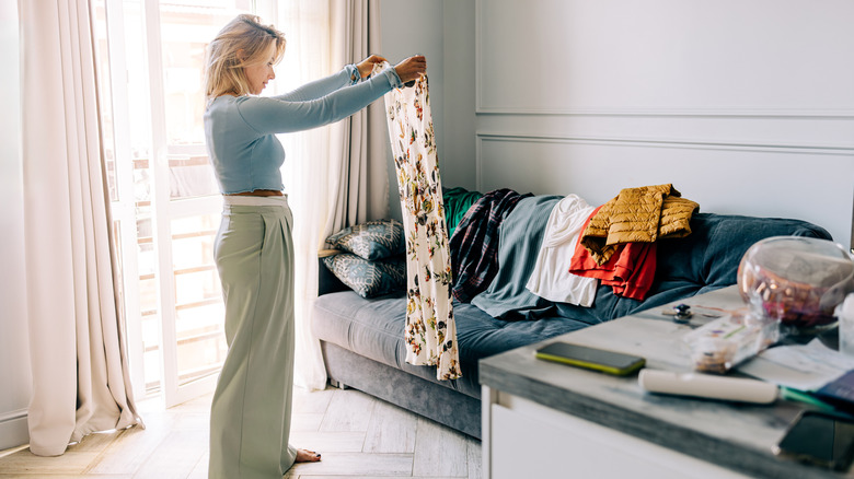 Femme dispensant tous ses vêtements alors qu'elle fait ses valises pour un voyage