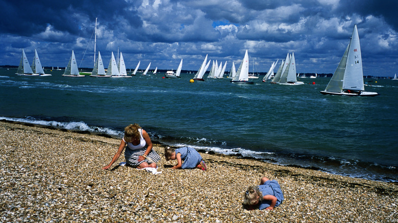 Famille sur la plage de Cowes avec des yachts sur l'océan