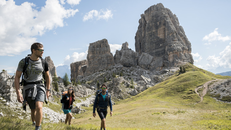 Groupe de randonneurs qui se jettent en montée vers le Cinque Torri dans les Dolomites, en Italie,