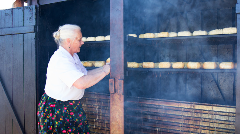 Une femme faisant du fromage Oscypek dans les montagnes de la Pologne Tatra