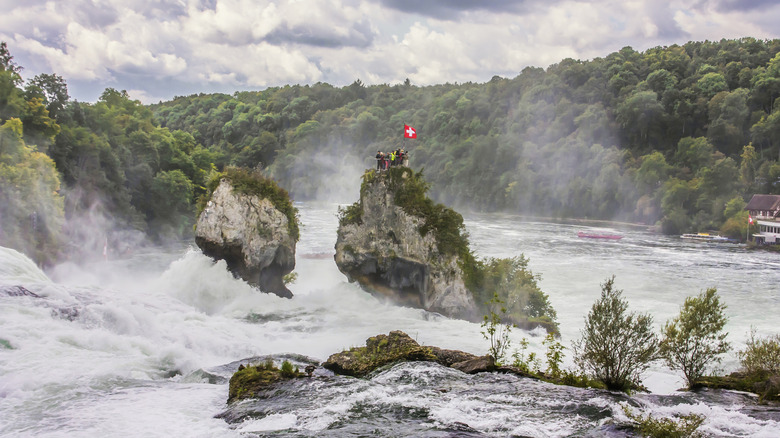 Rocky Island au milieu des chutes du Rhin avec un drapeau suisse rouge et blanc sur le dessus