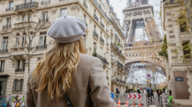 Une femme marche dans les rues de Paris près de la tour Eiffel