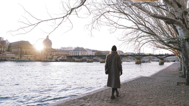 Une femme marche le long de la Seine à Paris, en France, pendant l'hiver