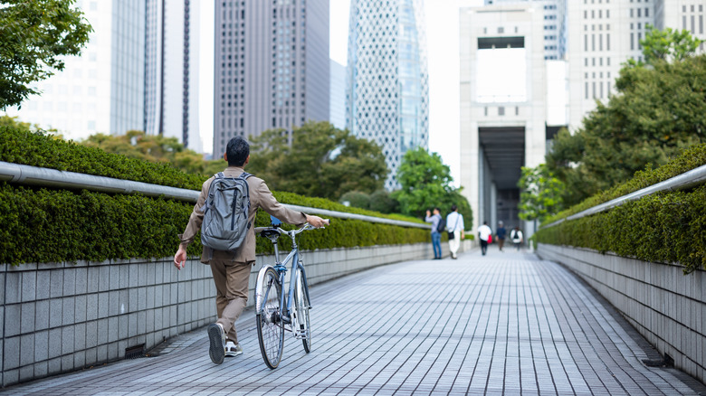 Un homme marchant avec son vélo à Tokyo