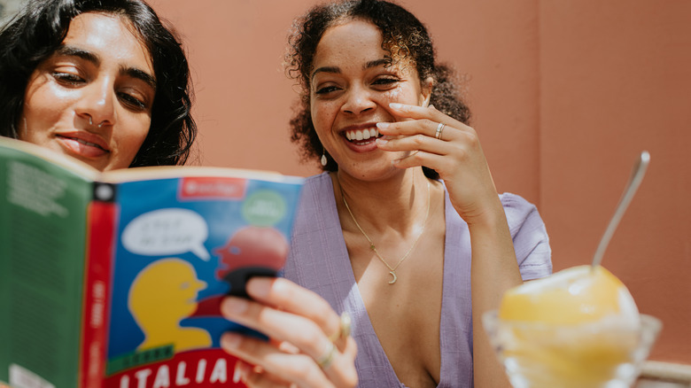 Deux femmes qui étudient l'italien à partir d'un livre